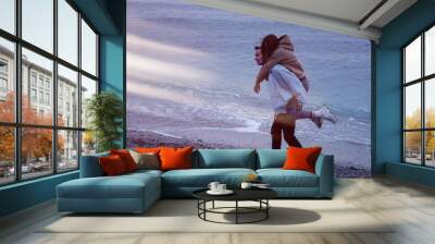 Young attractive couple resting on the sea. Wall mural