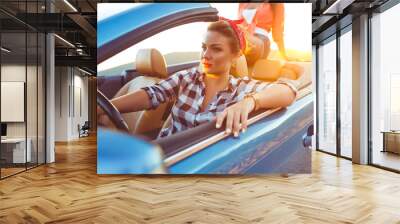 Two young happy girls driving a cabriolet Wall mural