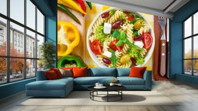 Pasta salad with tomato,arugula, cucumber, peppers,hot peppers, black and green olives, and cheese feta.  Top view. Wall mural