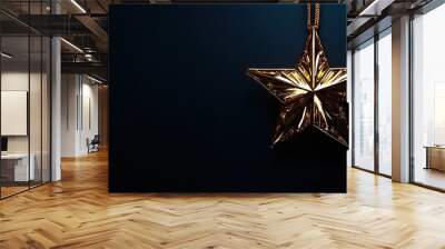 Gold star ornament hanging on dark background for festive decoration. Wall mural