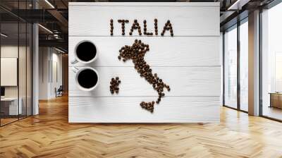 Map of the Italy made of roasted coffee beans laying on white wooden textured background with two coffee cups. Space for text Wall mural