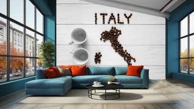 Map of the Italy made of roasted coffee beans laying on white wooden textured background with two coffee cups. Space for text Wall mural