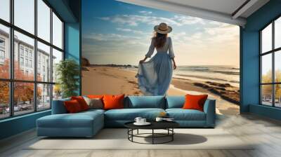 Beautiful woman in dress walking on the beach at sunset. Wall mural