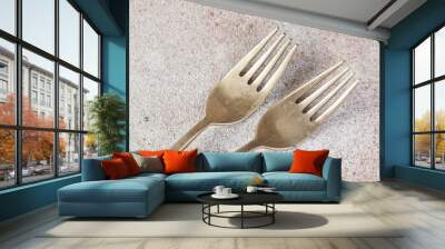 Two old bronze forks on concrete background. Wall mural