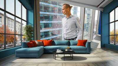 a young man stands at the window in the office Wall mural