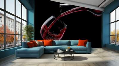 Red wine is poured into a wine glass on a black background. Wall mural