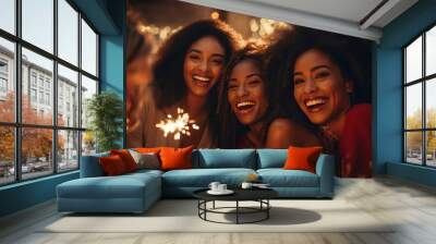 A group of young adult Black women with joyful smiles holding sparklers against a backdrop of night lights. Wall mural