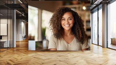 A young black woman with long curly hair smiles in a brightly lit indoor space. Wall mural