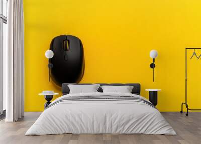 Black wireless mouse on yellow background Wall mural