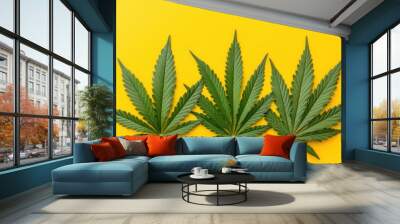 Fresh cannabis leaves on yellow background - botanical theme Wall mural