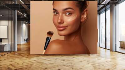 Radiant young woman applying foundation for flawless makeup look Wall mural