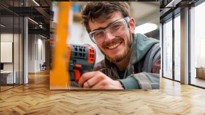 Smiling young white adult male working with power drill in workshop Wall mural