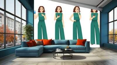 Young beatiful woman in green jumpsuit holding mobile phone, talking, texting and showing empty sreen isolated vector illustration Wall mural