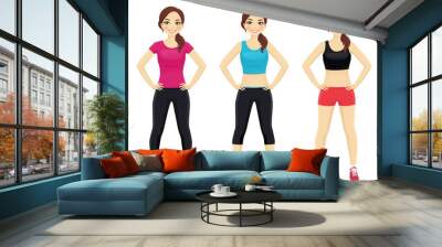 Young fit woman in different sportswear standing isolated Wall mural