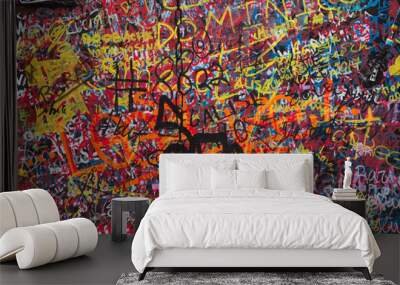 black wall is painted with small multi-colored graffiti Wall mural