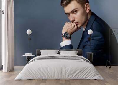 portrait of a man sitting with a suit with a watch, studio Wall mural