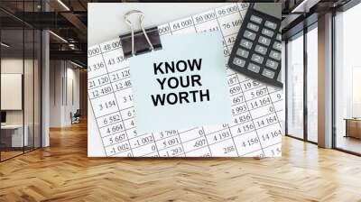 Know Your Worth inscription on the card on the clip on the table of reports and calculator Wall mural