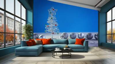 Christmas background with decorative silver Christmas tree and ball on blue background. Wall mural