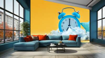 Soft blue pillow and blue alarm clock in pile of feathers on yellow background Wall mural