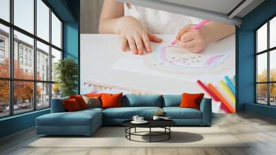 Close-up of a child's hands coloring a drawing with bright pencils. Young girl engaging in colorful artistic drawing and coloring activity using pencils. Enhancing creativity. Imagination Wall mural