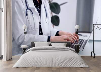 Doctor woman is using laptop computer at glass table in clinic. Medicine and pharmacy concept Wall mural