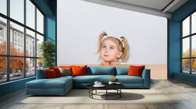 Little girl in casual clothes looking up and thinking Wall mural