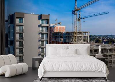 Aerial view of concrete frame of tall apartment building under construction in a city. Wall mural