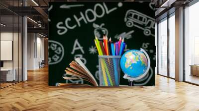 Back to school background with books, pencils and globe on white table on a green blackboard background. Wall mural