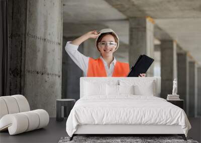 Construction concept of Engineer or Architect working at Construction Site. A woman with a tablet at a construction site. Bureau of Architecture. Wall mural