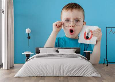 Cute little boy with letter on blue background. Child learning a letters. Alphabet Wall mural