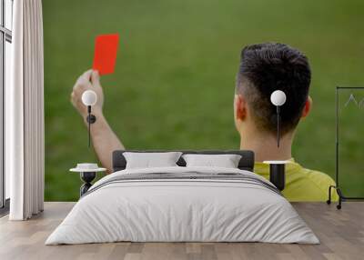 Referee showing a red card to a displeased football or soccer player while gaming. Concept of sport, rules violation, controversial issues, obstacles overcoming. Wall mural