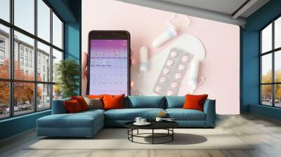 Tampon, feminine, sanitary pads for critical days, feminine calendar, pain pills during menstruation on a pink background. Tracking the menstrual cycle and ovulation Wall mural