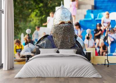 A man in medieval knight's clothing on the background grandstand with spectators Wall mural