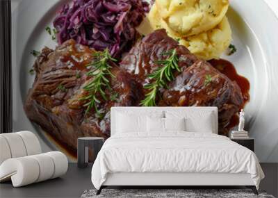 A serving of German sauerbraten, marinated pot roast with a side of red cabbage and potato dumplings, isolated on white background. Wall mural