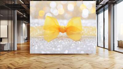 A soft pastel yellow ribbon bow on a white glitter background. The light, airy colors create a cheerful and bright look. Wall mural