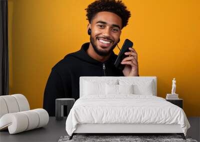 Black man with phone on studio background. Wall mural