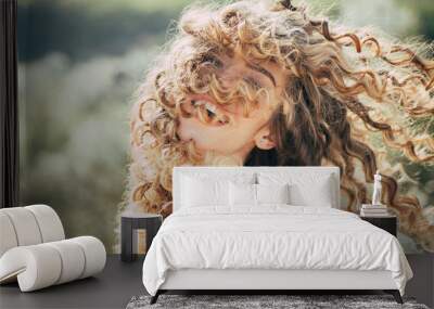 Blonde spring girl with curly beautiful hair smiling. Beauty hair Salon. Fashion haircut. Beauty girl with long and shiny curly hair. Trendy haircuts. Long healthy hair. Spring emotions. Wall mural