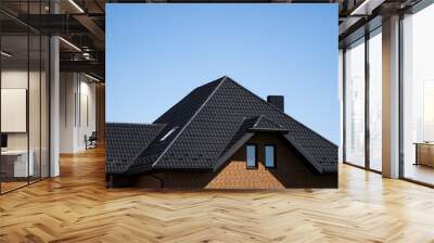 Brown corrugated metal profile roof installed on a modern house with a attic windows. The roof of corrugated sheet. Roofing of metal profile wavy shape. Modern roof made of metal. Metal roofing. Wall mural