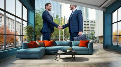 Business man shaking hands. Two businessmen handshake outdoor. Handshake business people. Handshake of two business man outdoor. Business man wearing modern suit in building city background. Wall mural