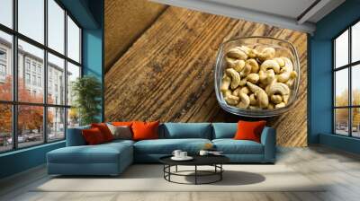 Cashew nuts in a small plate on a vintage wooden table as a background. Cashew nut is a healthy vegetarian protein nutritious food. Wall mural