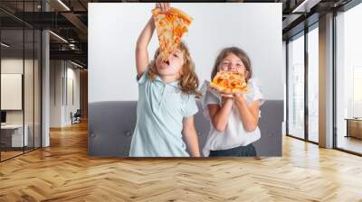 Children eating pizza. Cute funny kids little girl and boy eating tasty pizza. Wall mural