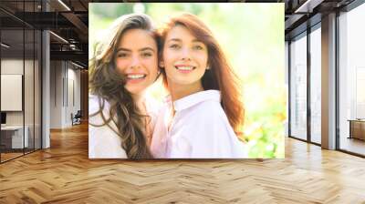 Close up portrait of two beautiful young girls with clear fresh young face skin and perfect nude makeup. Wall mural