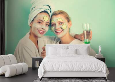 Girls friends sisters making clay facial mask. Anti age mask. Stay beautiful. Skin care for all ages. Women having fun cucumber skin mask. Relax concept. Beauty begins from inside. Spa and wellness Wall mural