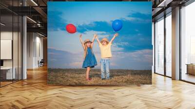 Happy children playing in summer. Little boy and girl enjoy life and nature. Little girl and boy enjoy walk. Happy girl and boy in the field. Positive little girl and boy. Wall mural