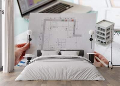 Interior designer working with an apartment plans in a studio, with blueprints and laptop on a table. Wall mural