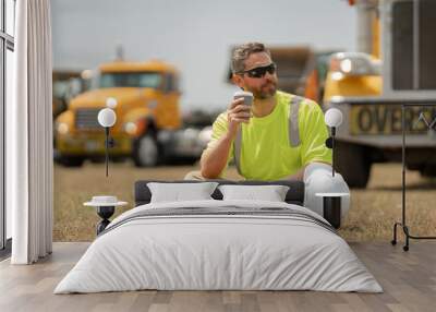 Hispanic worker relaxed after work on coffee break. Builder break relax time. Worker on lunch break. Engineer builder rest and relax on lunch near construction site and trucks. Truck driver, builder. Wall mural