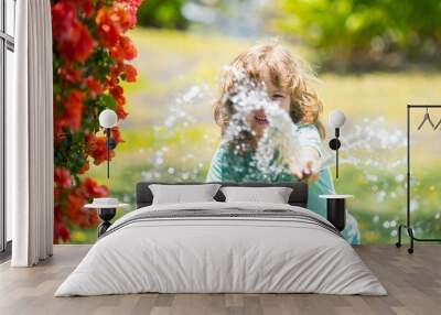 Kids play with water garden hose in yard. Outdoor children summer fun. Little boy playing with water hose in backyard. Party game for children. Healthy activity for hot sunny day. Wall mural