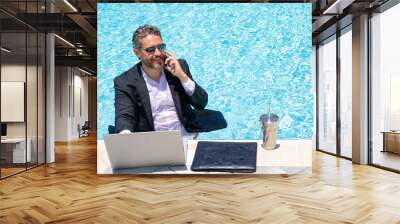 Outdoor business. Businessman tourist in suit rest on beach with laptop outdoor. Business man outdoor on summer vacation. Businessman on sea holding laptop. Businessman in sea. Office work outdoor. Wall mural