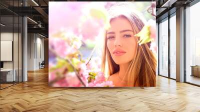 Outdoor fashion photo of beautiful young woman in flowers. Sensual girl on spring blossom background. Beauty romantic portrait of young pretty beautiful woman. Wall mural