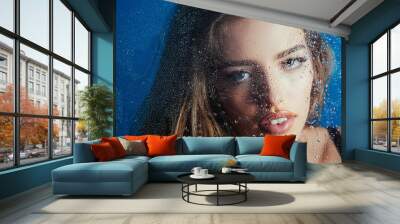 Rain drops on face of girl. Window with water drops before girl with makeup. Wall mural